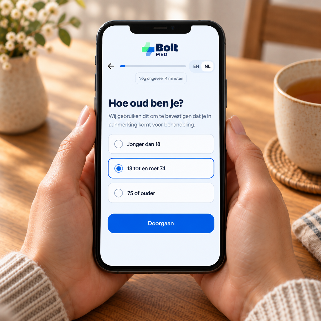 Handen met een smartphone met de BoltMed-vragenlijst ‘Hoe oud ben je?’, met een kop thee ernaast